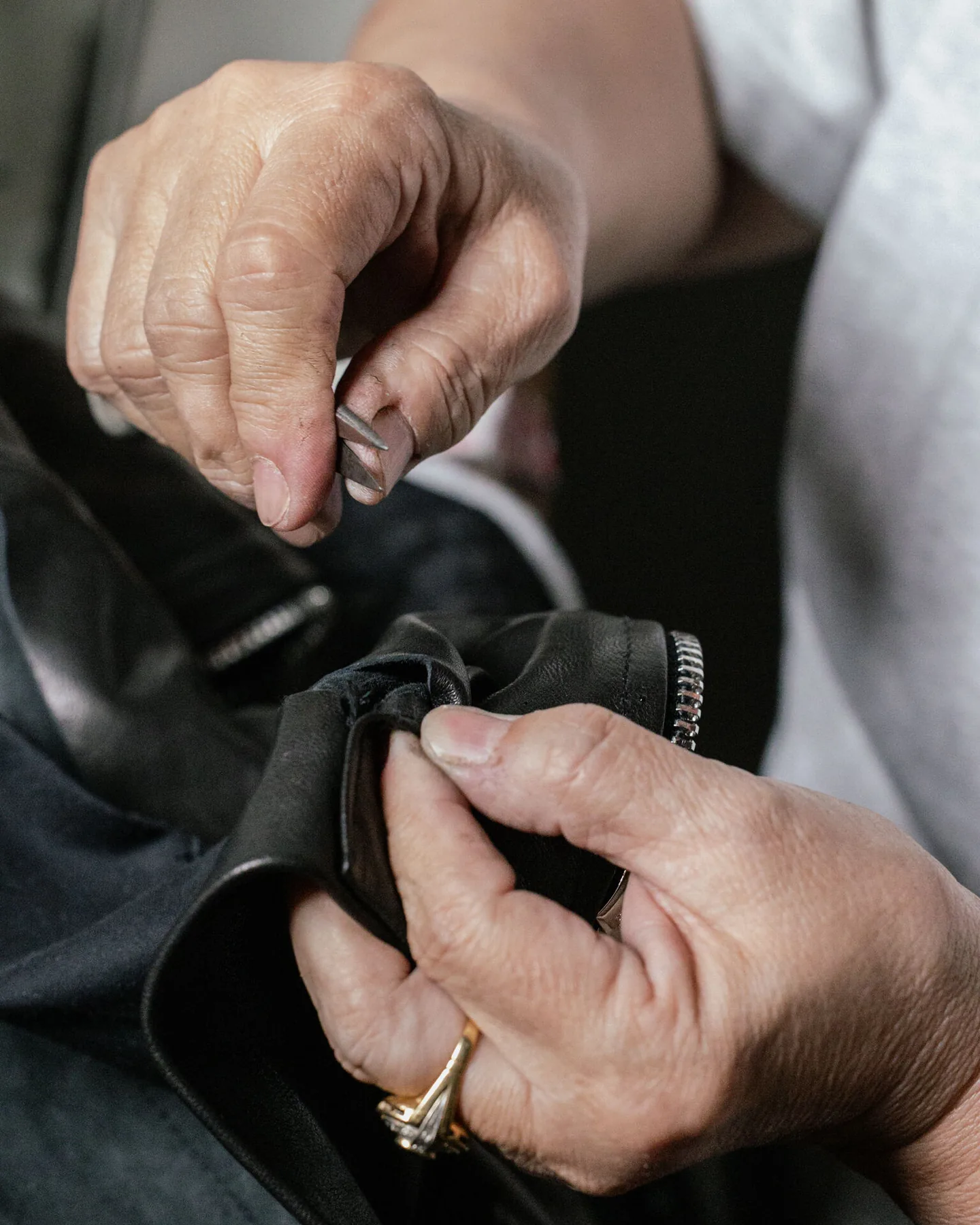 Marco Riva at the workbench in the Via del Proconsolo atelier, Florence, hand-stitching a bespoke leather jacket