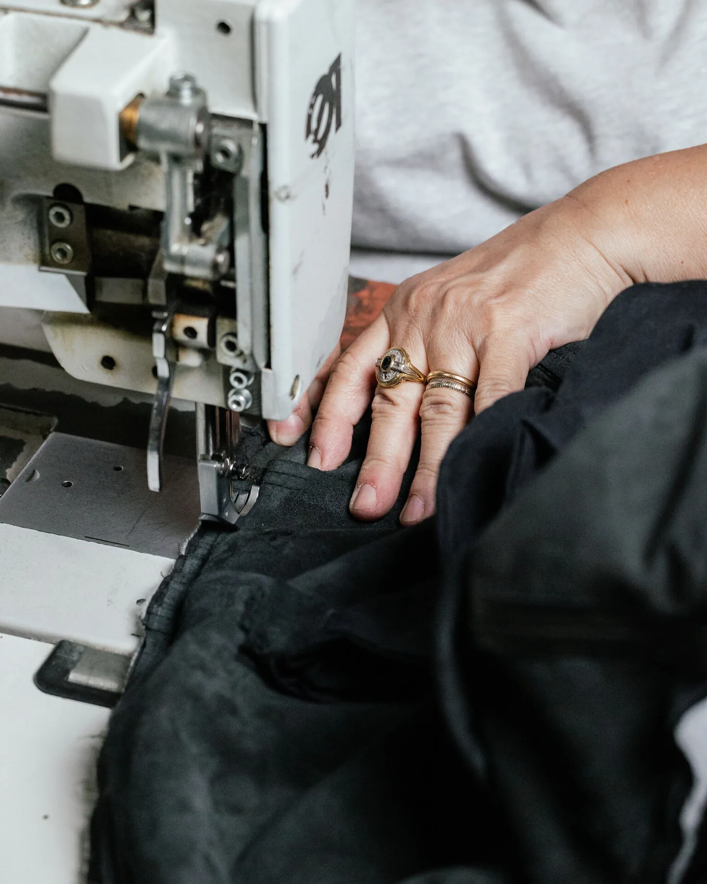 Riva Firenze atelier — hand at the industrial sewing machine, leather jacket in the making, Via del Proconsolo, Florence