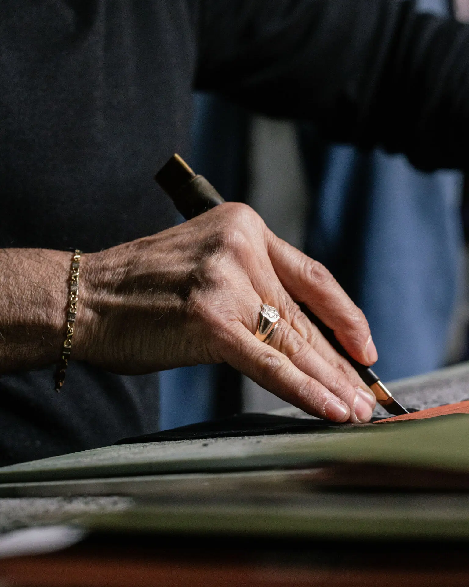 Marco Riva cutting a hide by hand on the workbench of the Via del Proconsolo atelier in Florence, for a bespoke leather jacket